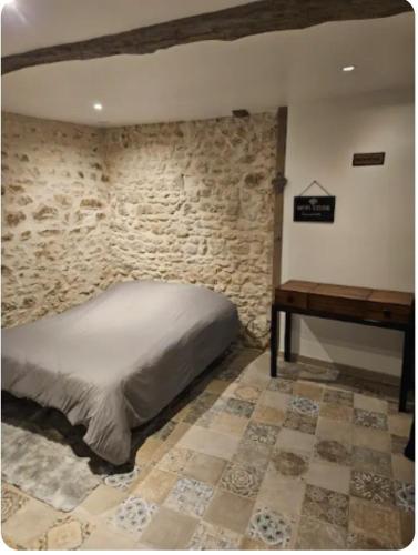 a bedroom with a bed and a wooden desk at L'appartement Tranquille in Maincy