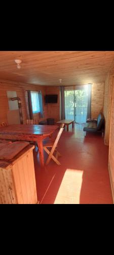 a room with a large wooden table in a cabin at Cabañas Oasis 2, Radal 7 tazas in Molina