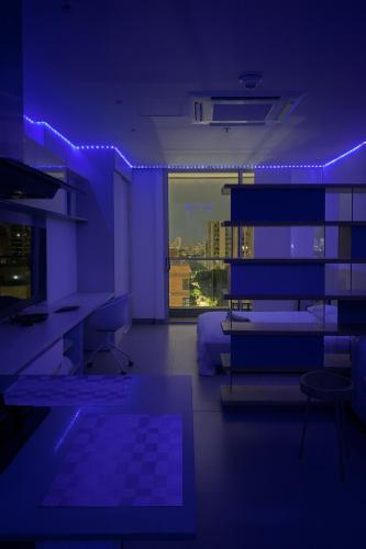 a blue room with a couch and a table and a desk at Distrito 90 luxury suites in Barranquilla