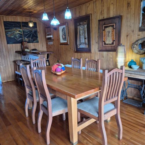 a dining room with a wooden table and chairs at Hostal Boutique El Vergel Azul in Castro