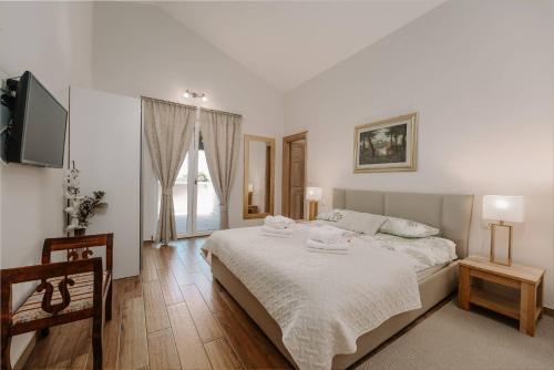 une chambre blanche avec un lit et une télévision dans l'établissement Villa Vista San Lorenzo, à Sveti Lovreč Pazenatički