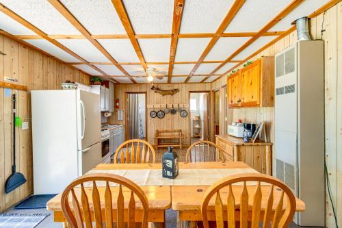 a kitchen with a wooden table and chairs and a refrigerator at Muskie Cabin on Mille Lacs Lake Boat and Fish! in Garrison