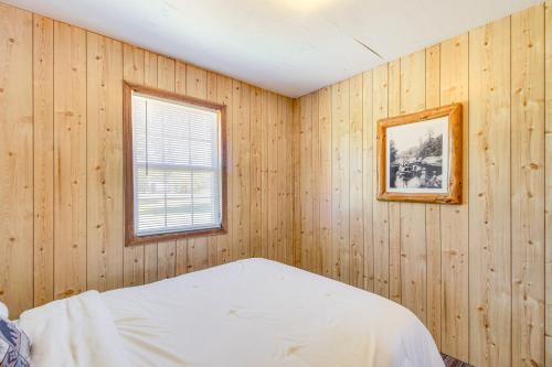 a bedroom with wood paneling and a bed and a window at Muskie Cabin on Mille Lacs Lake Boat and Fish! in Garrison