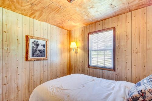 a bedroom with wooden walls and a bed with a window at Muskie Cabin on Mille Lacs Lake Boat and Fish! in Garrison