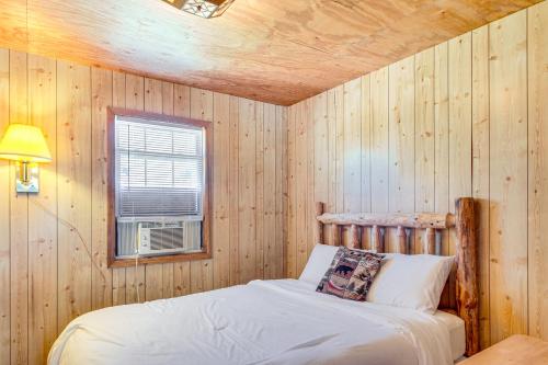 a bedroom with a bed in a wooden wall at Muskie Cabin on Mille Lacs Lake Boat and Fish! in Garrison