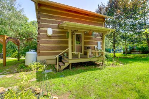 a small cabin with a porch in a yard at Riverfront Home with Fire Pit and Deck in Lansing in Lansing