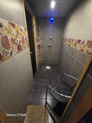 a bathroom with a shower with a chair in it at Willa Ranna Resort in Pärnu