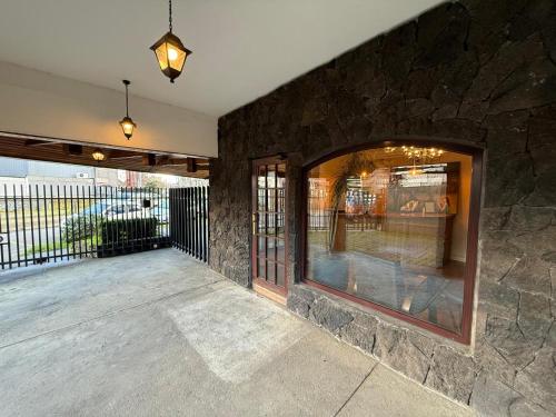 a patio with a stone wall and a large window at Torremolinos departamentos in Temuco