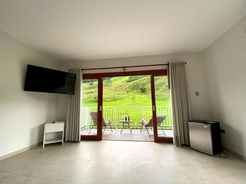 a living room with a large sliding glass door with a balcony at Göttlich Boutique Hotel in Pozuzo