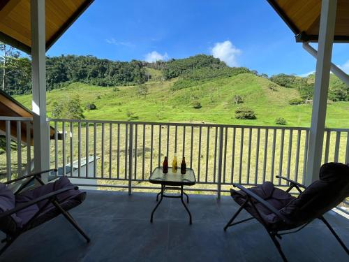 a porch with two chairs and a table and a mountain at Göttlich Boutique Hotel in Pozuzo