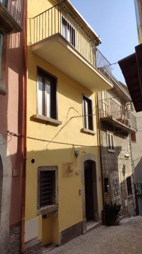 a yellow building with a balcony on top of it at Il Fungo in Cusano Mutri