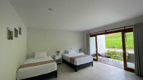 a bedroom with two beds and a balcony at Göttlich Boutique Hotel in Pozuzo