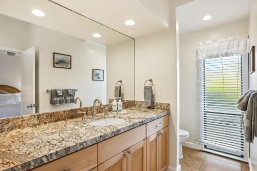a bathroom with a sink and a mirror at Poipu Sands 214 in Koloa