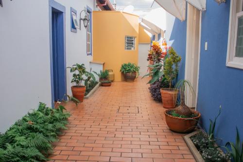 an alley with potted plants on the side of a building at Pousada Manga Rosa in São João Batista do Glória