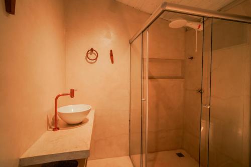 a bathroom with a sink and a shower at Evoé Caraíva in Caraíva