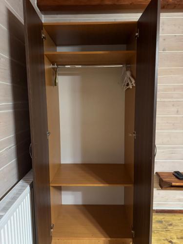 a closet with wooden shelves in a room at Готель TWINS РАЙ in Vorokhta