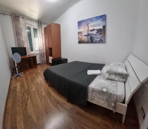 a bedroom with a bed and a desk with a computer at Appartamento Valentinis 74 in Monfalcone