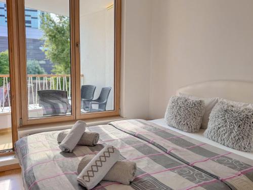 a bedroom with a bed with pillows and a balcony at Luxury apartment 304 - next to Sarajevo City Center in Sarajevo