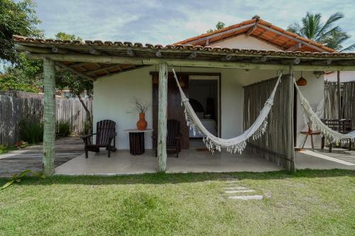 a pergola with hammocks on a patio at Evoé Caraíva in Caraíva