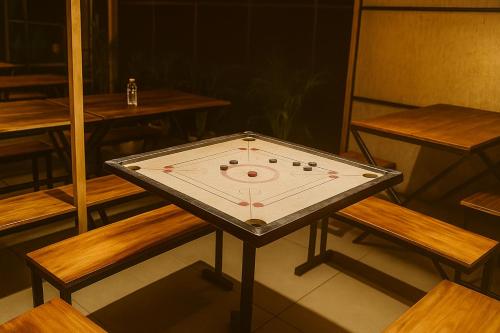 a ping pong table in a room with benches at Wetlands Wayanad Pool Resort with Natural Waterfalls in Padinjarathara