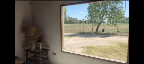 a window in a room with a view of a field at Quinta Verde Alojamiento Rural in Marcos Paz