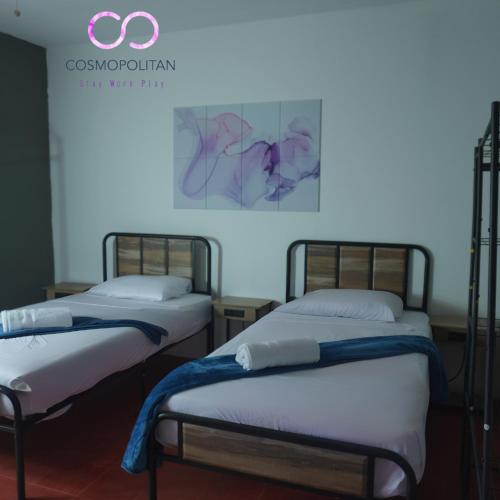two beds in a room next to each other at El Cosmopolitan Leon in León