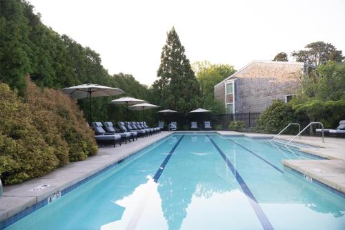 a swimming pool with chairs and umbrellas at Wequassett Resort and Golf Club in East Harwich