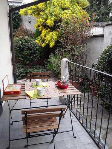 a table and a bench on a balcony at Mimosa House Torino in Turin