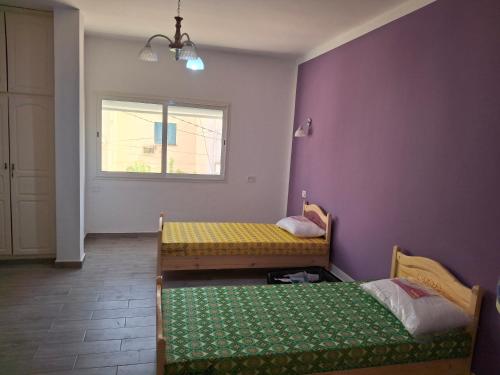 a room with two beds and a window at Full house with two bedrooms for seven bead in Mohammed Ben Bel Kassem