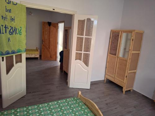 a living room with wooden floors and a room with doors at Full house with two bedrooms for seven bead in Mohammed Ben Bel Kassem