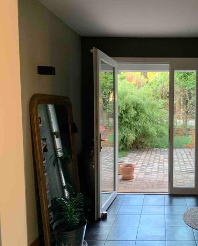 a room with a mirror and a door with a patio at Maison verdoyante et piscine in Abbans-Dessus