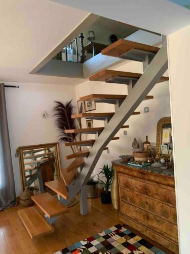 a wooden spiral staircase in a room with at Maison verdoyante et piscine in Abbans-Dessus