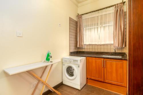 a laundry room with a washing machine and a window at Lake Victoria Residence - Stylish 2BR Apartment 10 mins to Airport in Entebbe