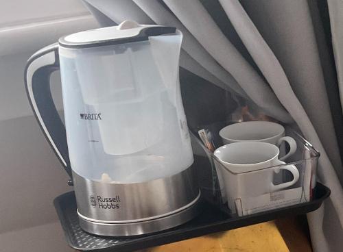 a blender sitting on a shelf next to a cup at PICCADILLY Private room and bathroom in Manchester