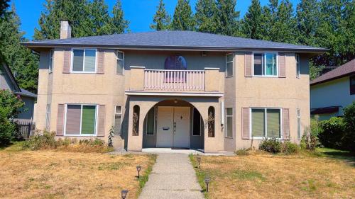 a large brick house with a porch and a balcony at Cozy Home near Downtown, UBC and YVR airport in Vancouver