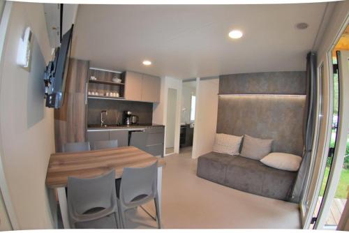 a kitchen and dining room with a table and chairs at Schwimmbad Camping Mössler in Döbriach