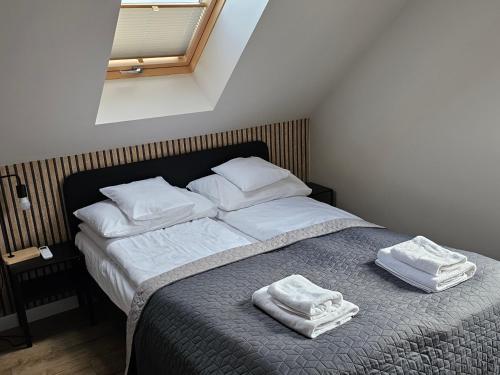 a bedroom with a bed with two towels on it at All Season Klimatyzowany dom przy szlaku z prywatnym tarasem i widokiem na Góry Orlickie - Sudety Sauna&Jacuzzi, Skalne Miasto, 4km do Zieleniec SKI Arena in Lasowka