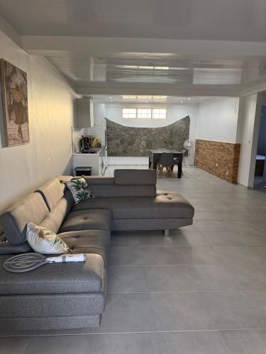 a living room with two couches and a kitchen at Bas de villa à découvrir in Rivière-Pilote