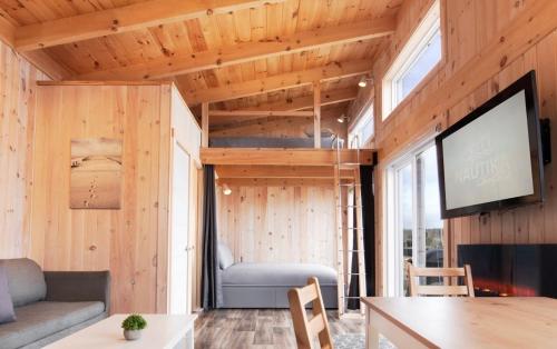 a tiny house with a living room with a flat screen tv at Chalets Nautika in Gaspé