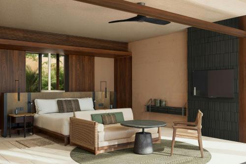 a bedroom with a bed and a couch and a tv at Siari, a Ritz-Carlton Reserve 