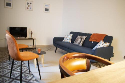 a living room with a blue couch and chairs at Mimosa House Torino in Turin
