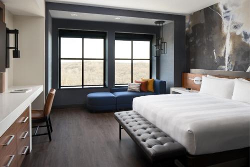 a bedroom with a large bed and a blue couch at Marriott Owings Mills Metro Centre in Owings Mills