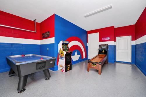 a room with two arcade games and a pool table at Grand Home Near Disney With Private Pool, Air Hockey Table And Waterpark & Resort Access At Encore Resorts Reunion - 401Sf in Kissimmee