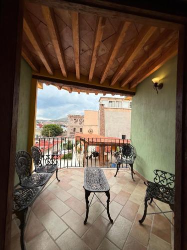 a patio with chairs and a table and a balcony at Hotel Antiguo Vapor Categoría Especial in Guanajuato