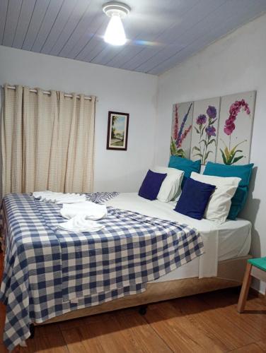 a bedroom with a large bed with blue and white sheets at Casinhas de Pipa in Pipa