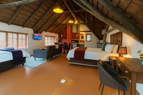 a hotel room with a bed and a dining room at Lipizzaner Lodge - Kyalami, Midrand in Kyalami