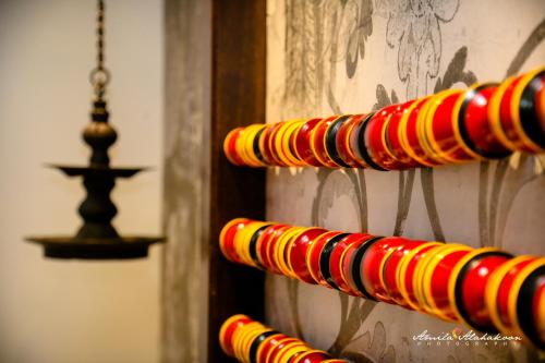 a row of red and yellow plates on a wall at Serendib Signature Resort in Digana