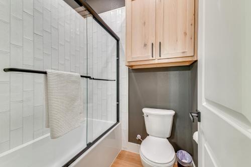 a bathroom with a toilet and a glass shower at Rural Home with Hot Tub Less Than 7 Mi to Winery and Golfing in Muenster