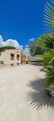 a building with a palm tree in front of it at Villa Calatafimi Segesta in Calatafimi