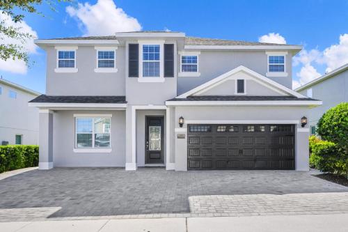 ein weißes Haus mit Garage in der Unterkunft Regal Home With Private Pool Near Disney With Waterpark & Resort Access At Encore Resort - 7727Ff in Kissimmee